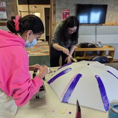 Riley and Catherine C painting an umbrella props for the Oz production