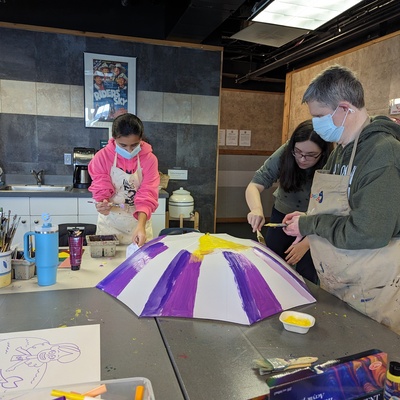 Spencer joins Catherine C and Riley to paint an umbrella prop
