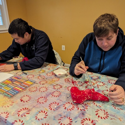 Gavin and Ian painting red masking tape slippers- their first tape sculptures