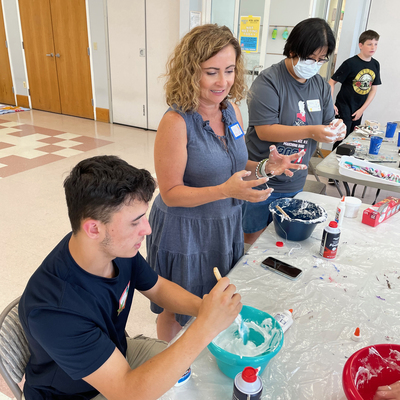 Executive Director Val Walters gets messy making slime with teens at the FORT