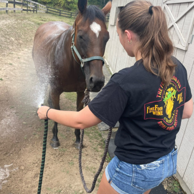 Sophia hosing off Tika on a hot day.